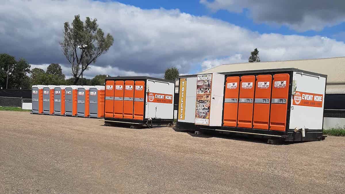 Three event hire toilet blocks on a dirt ground