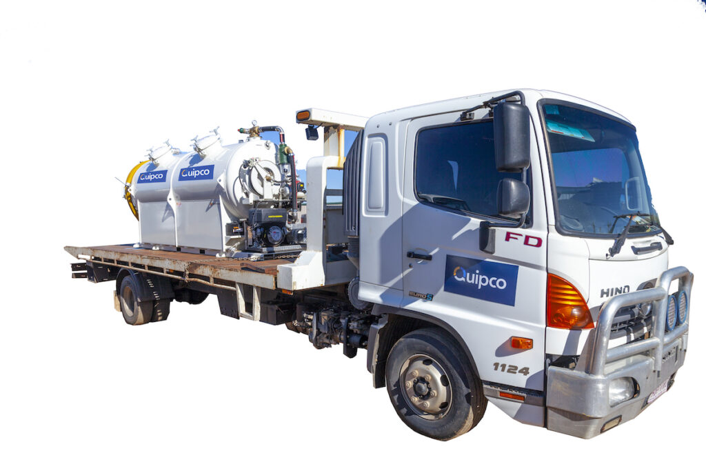 A Quipco liquid waste disposal truck on a white background