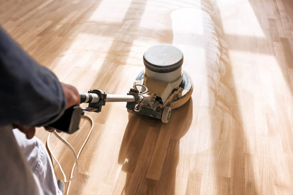 A quipco employee polishing floors as part of a builders clean